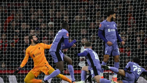 Liverpool players try to block Martin Odegaard's effort which hit the bar at the Emirates