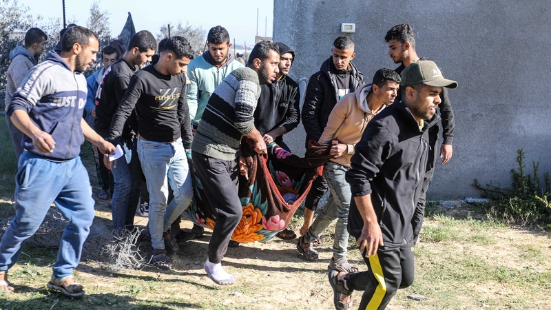 People search for victims in a building that was destroyed during Israeli airstrikes in Rafah