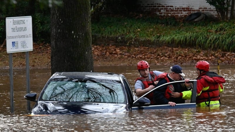 Firefighters rescue a man in a flood in Charlotte, North Carolina