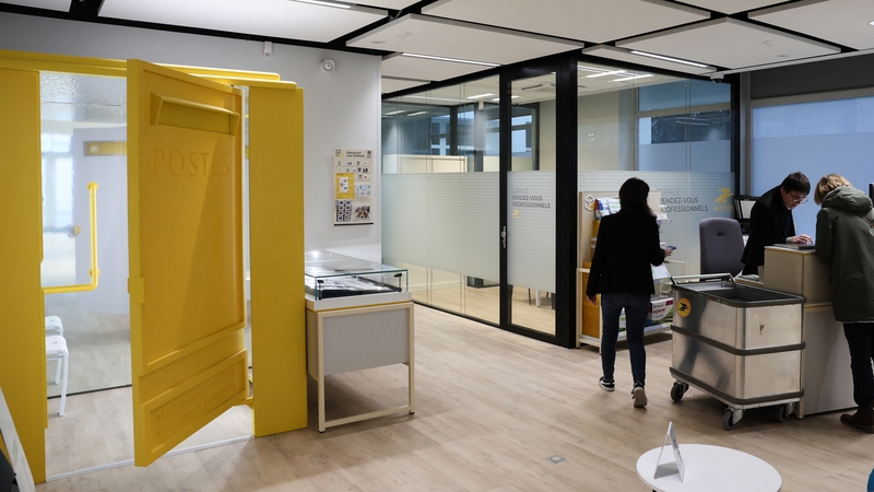 A client stands near a retry booth set up in a La Poste French post office in Paris