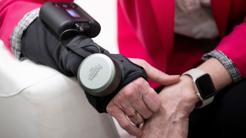 Roberta Wilson-Garrett, who has Parkinson's disease, poses with her GyroGlove, made by GyroGear at CES