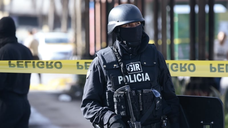 Police officers stand guard after a bomb threat was received at El Playón de La Marín in Quito, Ecuador