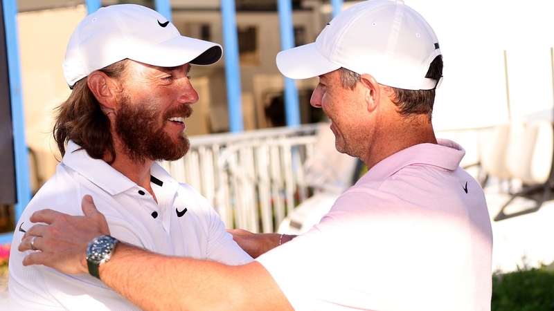 Tommy Fleetwood and Rory McIlroy embrace after their third rounds at Dubai Creek Golf and Yacht Club