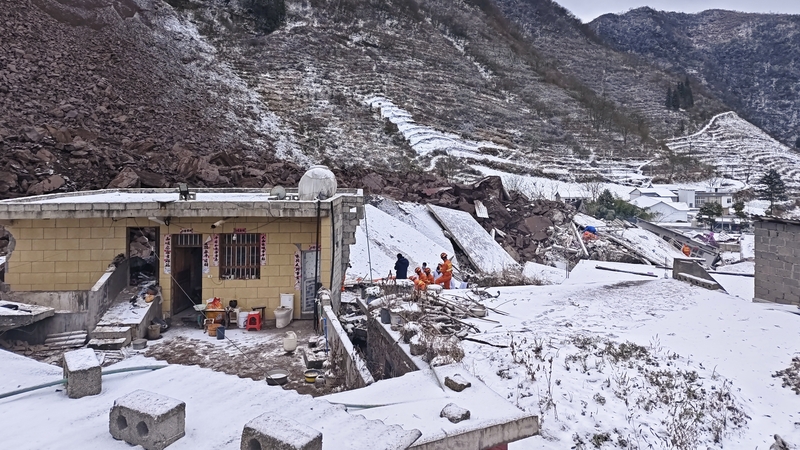 Rescuers search for survivors at the ruins of a landslide in Zhenxiong County