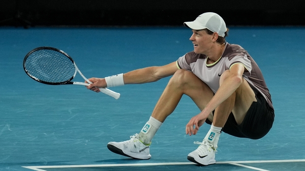 Italy's Jannik Sinner falls to the ground after winning the 2024 Australian Open