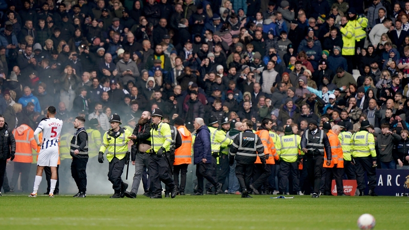 Police officers on the field after the match was halted due to a pitch invasion