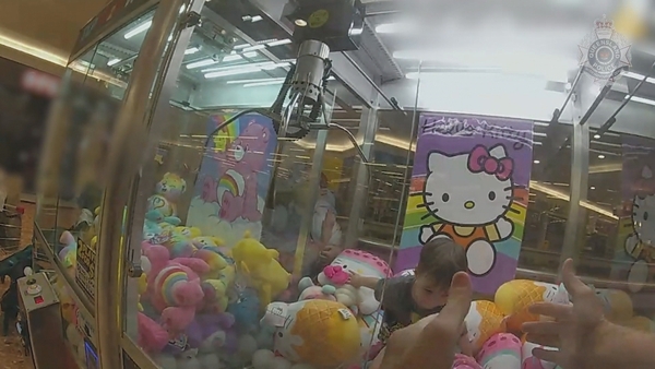 The little boy climbed into the maching through the prize dispenser chute