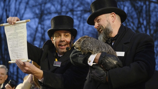 Groundhog Day Inner Circle Vice President Dan McGinley announces the weather prognostication as groundhog handler AJ Dereume holds Punxsutawney Phil after he did not see his shadow predicting an early Spring