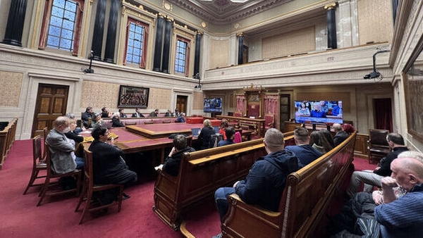 People in Stormont watch speakers on the television screen (RollingNews.ie)