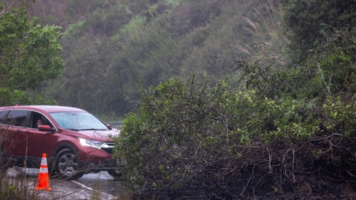 A driver is turned back by a mudslide blocking the road as atmospheric river storms batters California