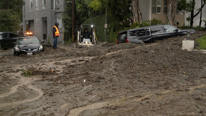 Workers clear a debris flow in Beverly Hills during an atmospheric river storm