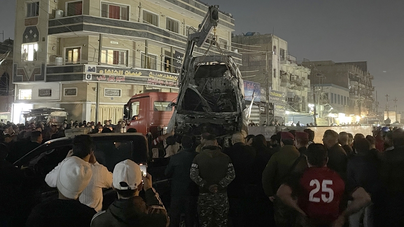 A crane lifts the wrecked car targeted in the US drone strike