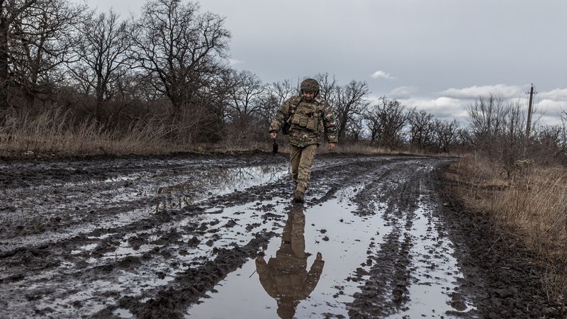 A Ukrainian soldier seen walking along a road towards Bakhmut