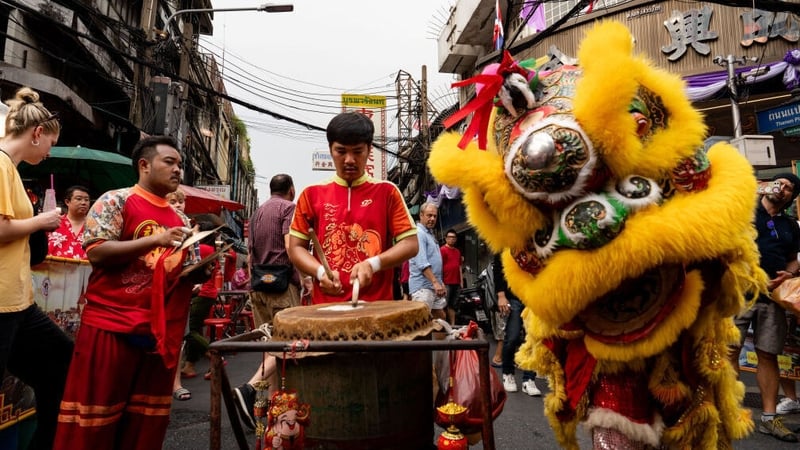 The dragon ensemble performs on the street as people visit Yaowarat Chinatown on Lunar New Year in Bangkok, Thailand