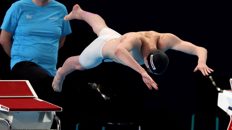 Daniel Wiffen dives from the blocks in the heats of the 400m freestyle