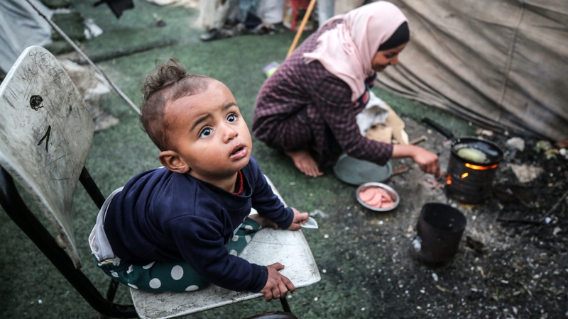 Palestinian children are seen near makeshift tents at a camp set up in Al-Durra Stadium in Deir Al-Balah in Central Gaza