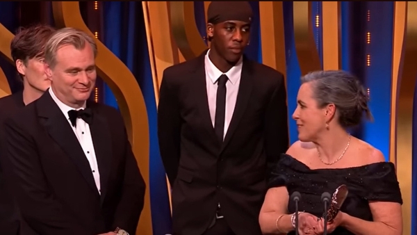 A stage invader joined Christopher Nolan and Emma Thomas as they accepted the Best Film Award at the BAFTAs / Image: BBC One / BAFTAs
