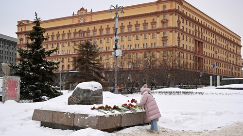 A woman lays flowers for Alexei Navalny at the Solovetsky Stone in Moscow