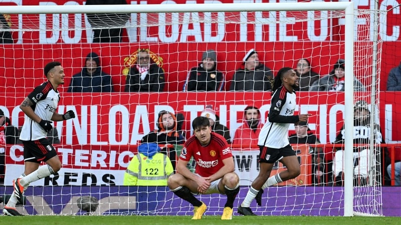 Alex Iwobi (R) celebrates his winner as a dejected Harry Maguire looks on