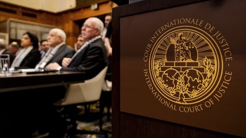 The logo of the International Court of Justice is seen next to Minister of Foreign Affairs of the Palestinian Authority Riyad al-Maliki