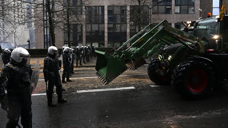 A farmer in a tractor seen in a standoff with riot police this morning in Brussels as ministers met