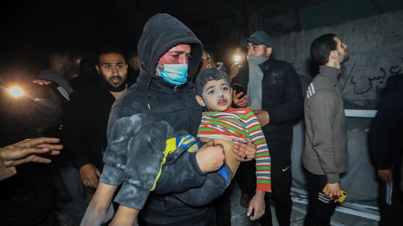 A Palestinian child is evacuated from a building hit by Israeli air strikes in Rafah
