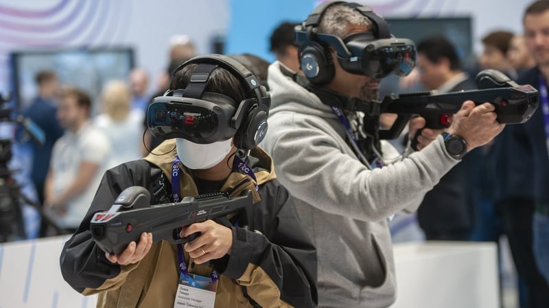 Attendees playing a game with the HTC Vive virtual reality equipment during their visit to MWC in Barcelona