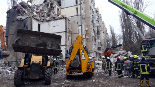 Rescuers remove rubble at a residential building destroyed by a Russian drone in Odesa