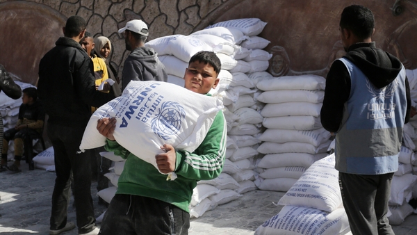 People receive flour distributed by UNRWA in Gaza