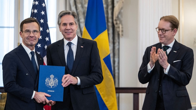 Antony Blinken, centre, receives NATO ratification documents from Ulf Kristersson, left, during a ceremony in Washington