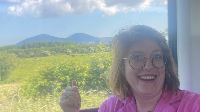 Bláithín ar an Traein. Paps of Anú, bandia na ndéithe Cheilteacha, sa chúlra.