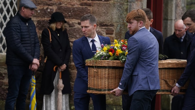 Brian Sheridan (L) helps carry his brother's casket to St Ibar's Church in Castlebridge