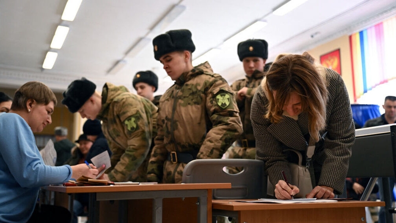 A woman and Russian service members register to vote in Russia's presidential election in Moscow