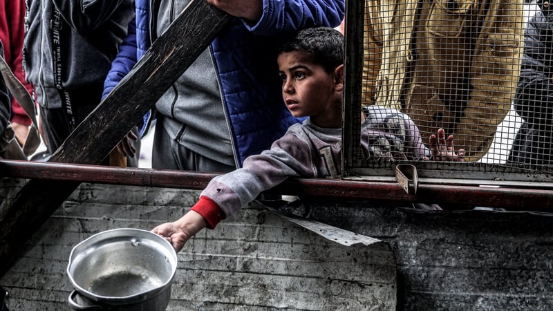 A boy awaits with other displaced Palestinians queueing for meals provided by a charity organisation ahead of the fast-breaking 'iftar' meal during the Muslim holy month of Ramadan