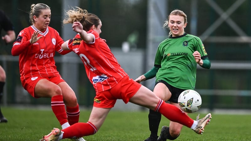 Erica Burke of Peamount is tackled by Maggie Pierce and Lucy O'Rourke of Shels