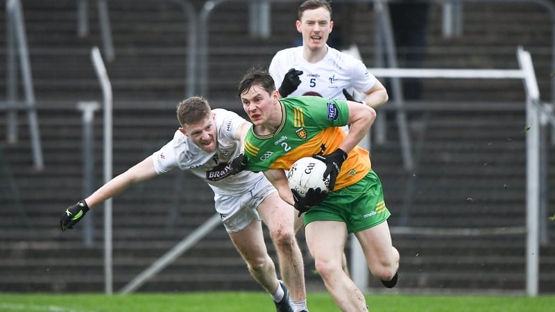 Barry Kelly of Kildare clings on to Donegal's Mark Curran
