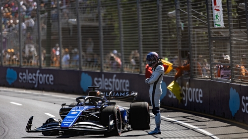 Alex Albon stands by his Williams car after crashing out during the first practice session