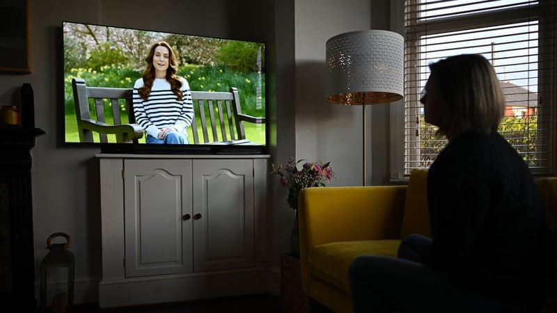 A woman watches television, as Britain's Princess of Wales announces she is receiving a preventative course of chemotherapy for cancer