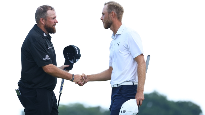 Shane Lowry (L) shakes hands with eventual winner Jesper Svensson after they completed their rounds