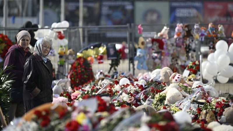 People continue to lay flowers and light candles at the site of the attack