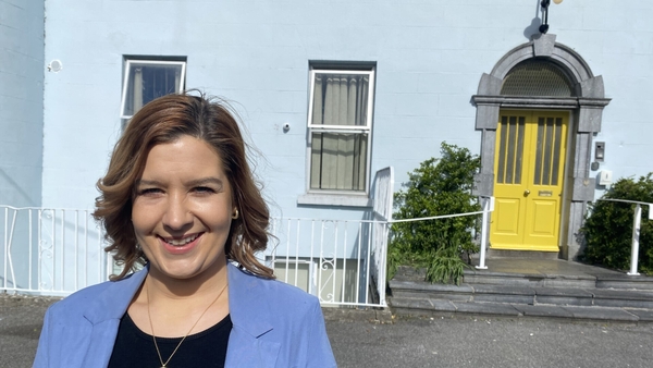 Good Shepherd Centre regional manager Catherine White in front of their freshly-painted bright yellow door