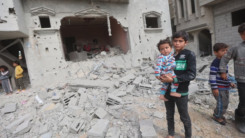 Children are seen beside a destroyed building after Israeli airstrikes in Khan Younis