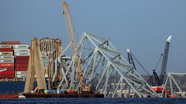 Cranes work on clearing debris from the Francis Scott Key Bridge