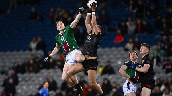 Ray Connellan of Westmeath cobtests the throw-in Pat Havern of Down