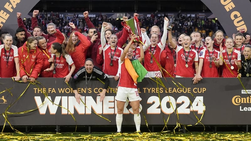 Katie McCabe lifts the trophy after Arsenal's triumph