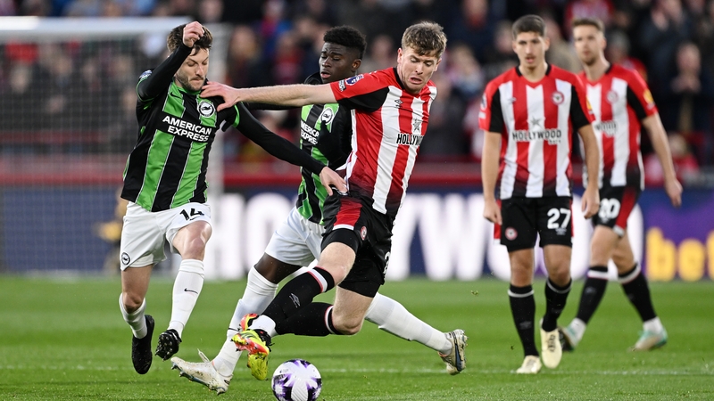 Brentford and Ireland centre-back Nathan Collins is challenged by Adam Lallana (L) and Carlos Baleba of Brighton & Hove Albion (C) during the encounter