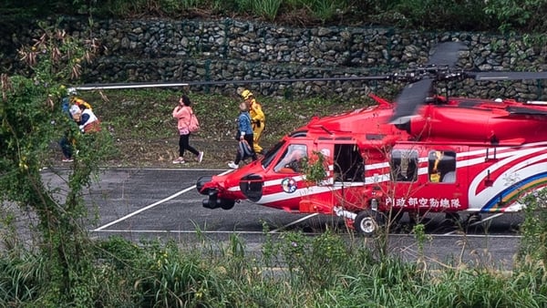 People are brought to safety by rescue personnel from a National Airborne Service Corps helicopter at a parking area in Taroko National Park