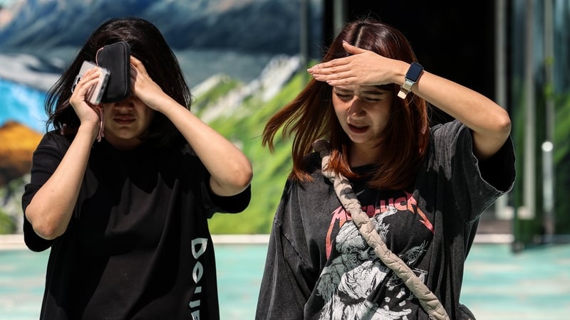 People pictured on 1 April trying to shade from the sun during a heatwave in Bangkok, Thailand