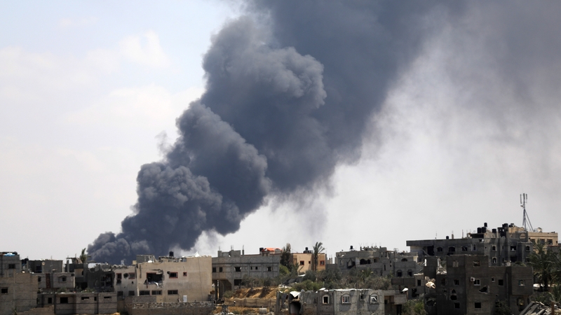 Black smoke rises among the residential buildings after Israeli attacks in Khan Younis