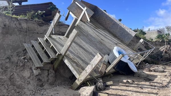 Decking dangles between sand dunes and the shore after the recent Storm Kathleen